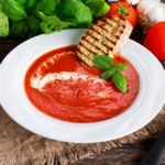 Smooth and sweet tomato soup, seasoned with basil, garlic